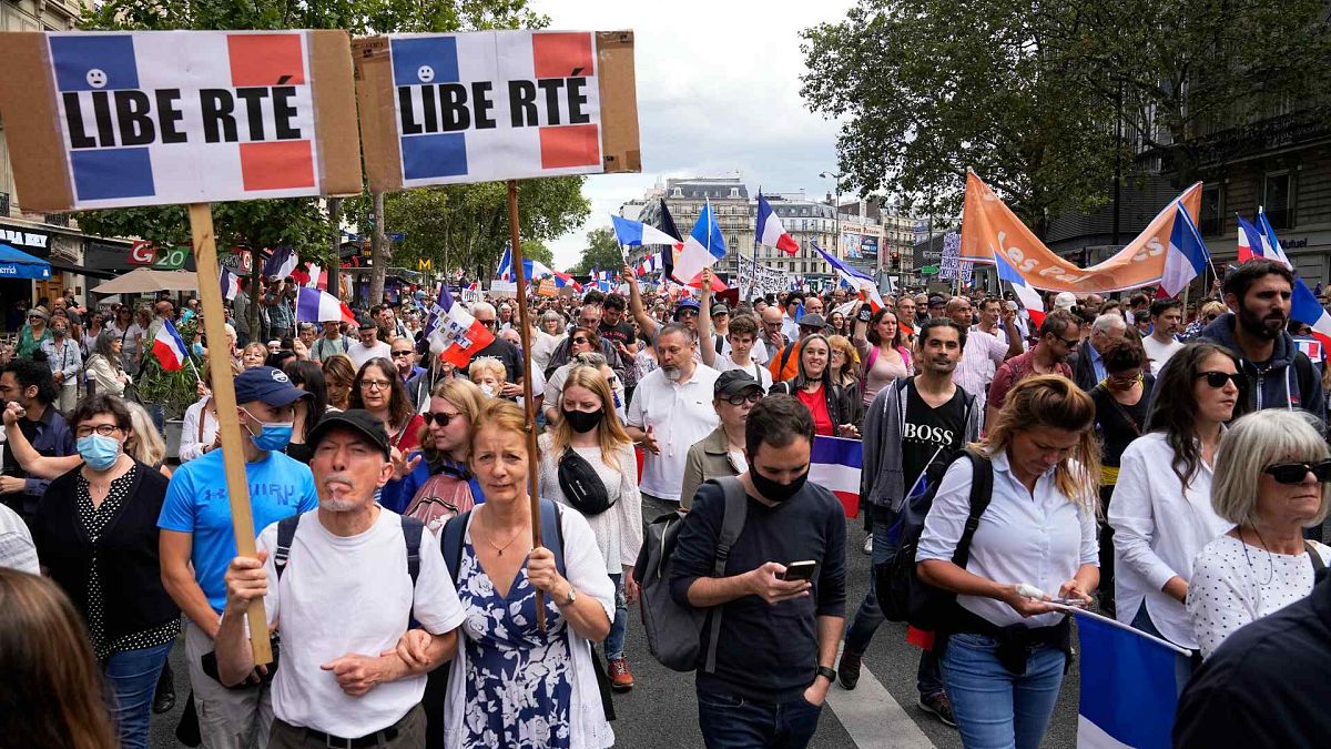 متظاهرون يرفعون لافتات كُتب عليها بالفرنسية "الحرية" بينما يلوح آخرون بالأعلام الفرنسية أثناء مشاركتهم في مظاهرة في باريس، فرنسا، السبت 31 يوليو 2021