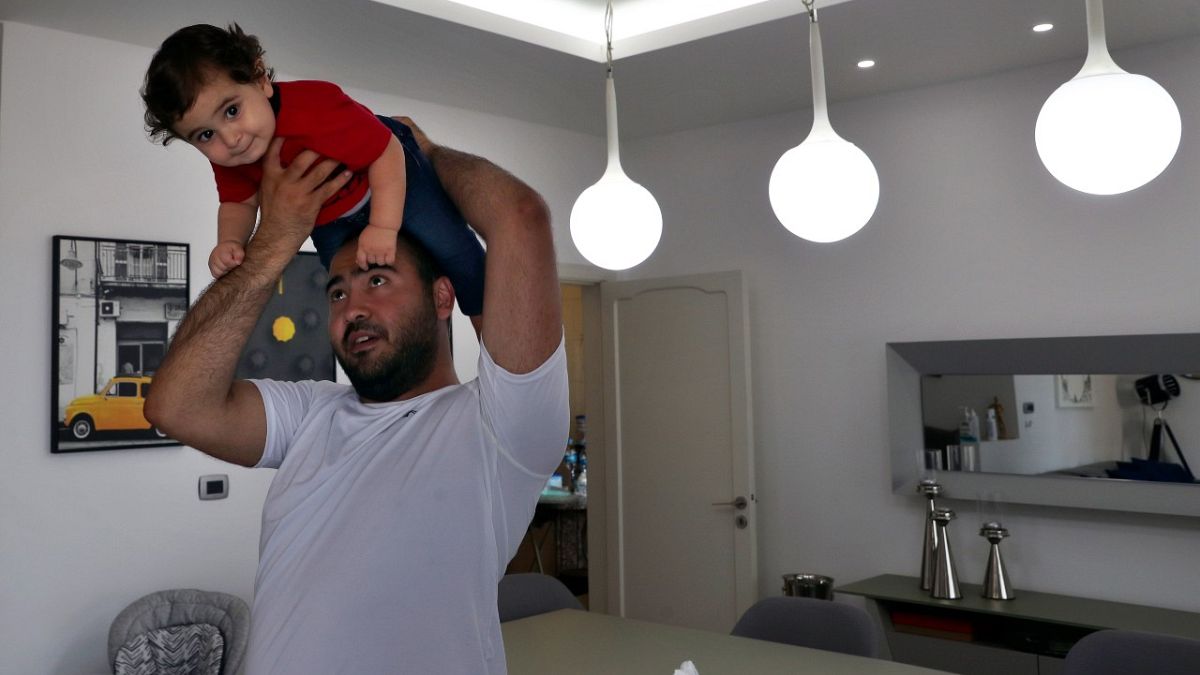إدموند خنيصر مع طفله جورج في بيتهما في جل الديب شمال بيروت، 10 يوليو 2021