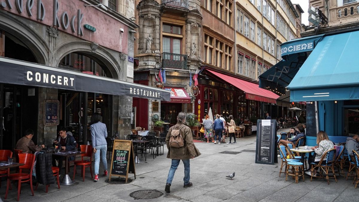 رجل يمشي بجوار أحد المطاعم في ليون، وسط فرنسا