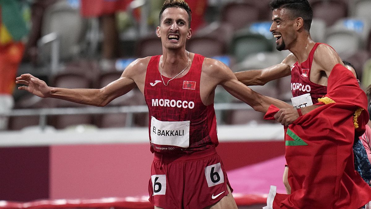 المغربي سفيان البقالي يحتفل مع مواطنه محمد تندوفت بفوزه بذهبية نهائي سباق 3000 متر حواجز في دورة الألعاب الأولمبية الصيفية 2020 في طوكيو.