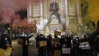 نساء يحملن مشاعل ملونة خلال مظاهرة تندد بالعنف الأسري للمرأة في باريس، فرنسا.