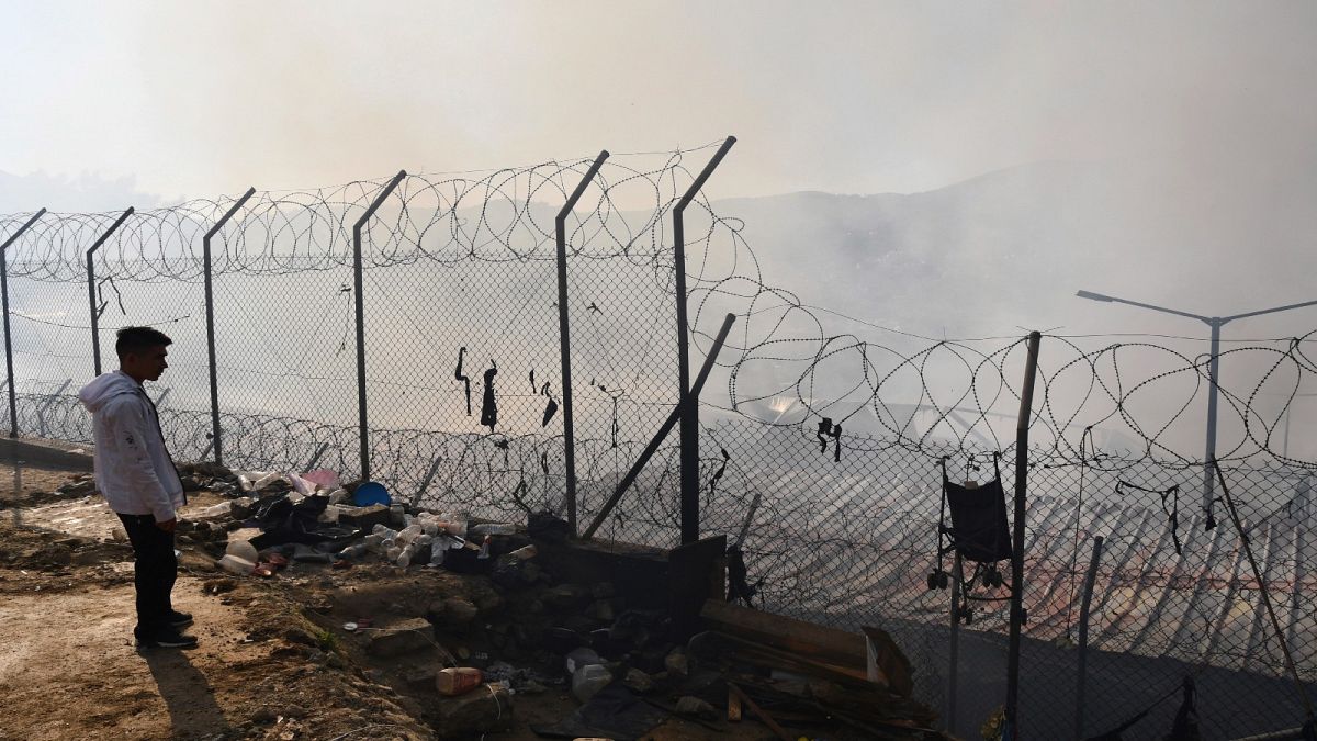 ARCHIVO - El 11 de noviembre de 2020 un migrante se encuentra fuera de un campamento de refugiados después de un incendio en la isla