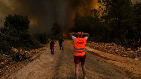 People watch the fire raging over Antalya, Turkey, Sunday August 1