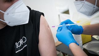A man is getting vaccinated against COVID-19 at a drive-through vaccination center outside an IKEA store in Berlin.