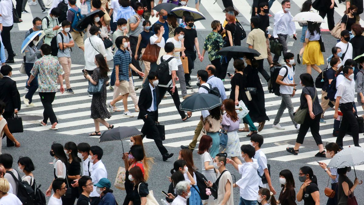 Japonya'nın başkenti Tokyo'da kalabalık bir caddede yürüyen vatandaşlar