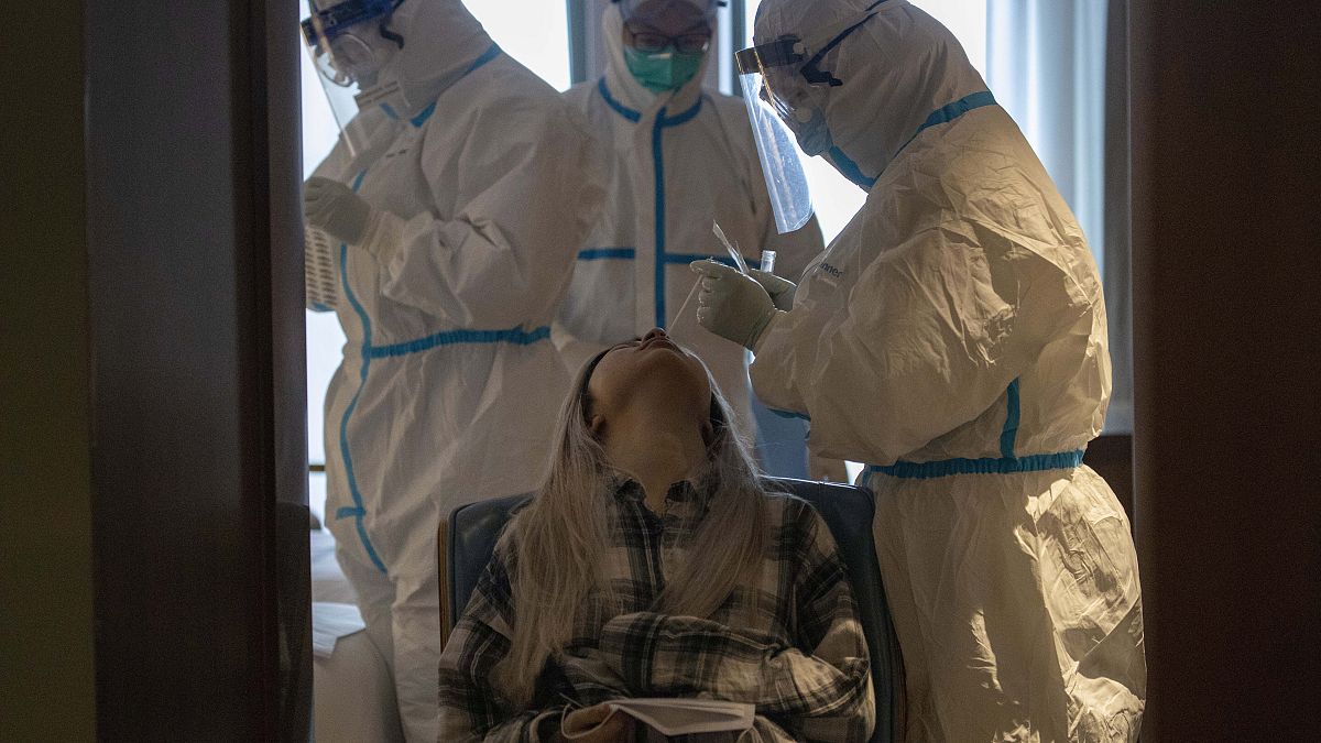 A woman takes a COVID-19 test at a quarantine hotel in Wuhan in central China's Hubei province on Tuesday, March 31, 2020.