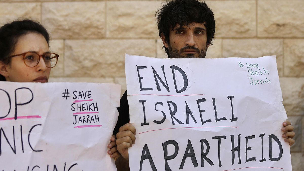 متظاهرون يحملون لافتات خلال جلسة استماع حول عمليات إخلاء محتملة لفلسطينيين من حي الشيخ جراح في القدس ، خارج المحكمة العليا في القدس