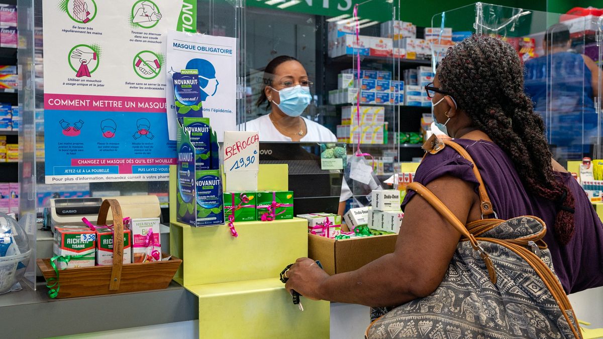 A pharmacist welcomes a client in Pointe-a-Pitre, on the French Caribbean archipelago of Guadeloupe, on July 30, 2021.