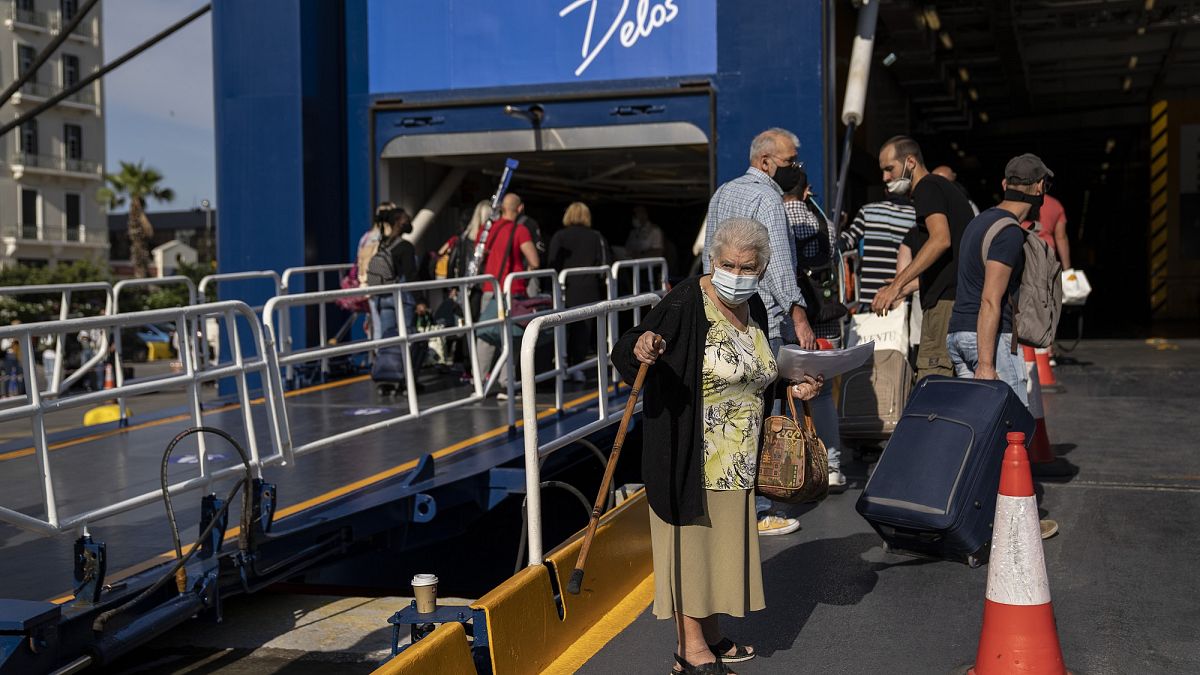 Ηλικιωμένη ετοιμάζεται να επιβιβαστεί σε πλοίο για τις Κυκλάδες - Λιμάνι Πειραιά, καλοκαίρι 2021