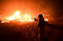 Un hombre lucha contra le fuego en Adames, al norte Atenas, Grecia