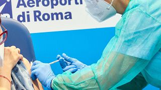 Επιβάτης πτήσης που μόλις έχει προσγειωθεί στο αεροδρόμιο Φιουμιντσίνο της Ρώμης, εμβολιάζεται κατά Covid-19/