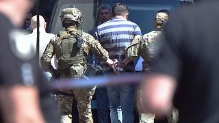 A man is arrested by Ukraine's special forces officers after he threatens to detonate a grenade inside the government building in Kiev on August 4, 2021.