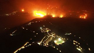 A wildfire approaches the Olympic Academy, foreground, in ancient Olympia, Wednesday, Aug. 4, 2021. 