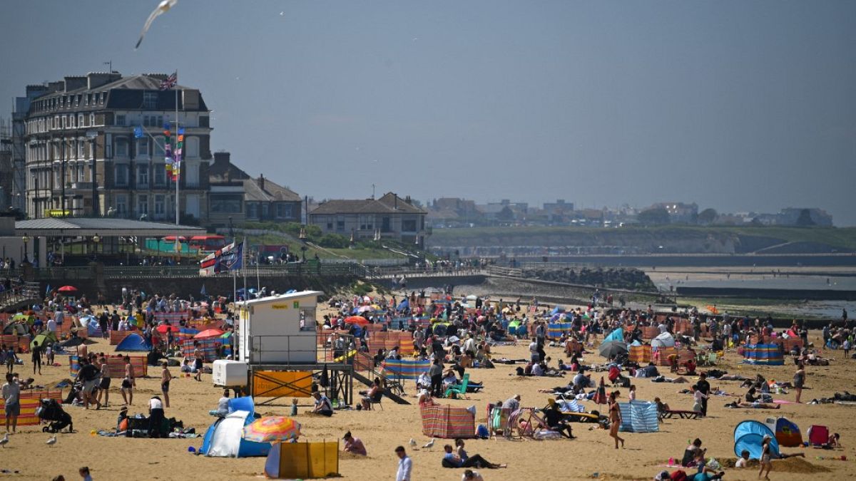 Sunbathers take advantage of the fine weather on the beach on the coast at Margate, east of London on May 31, 2021.