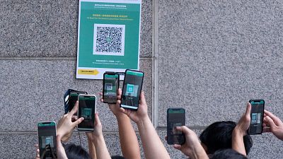 Visitors scan a QR code for the Hong Kong government's "Leave Home Safe" app to trace people in the advent of any Covid-19 outbreaks Visitors scan a QR code for the Hong Kong government's "Leave Home Safe" app to trace people in the advent of any Covid-19 outbreaks