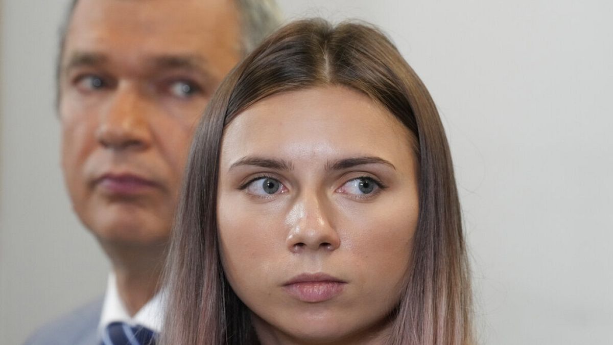 Exiled Belarusian Olympic sprinter Krystsina Tsimanouskaya, right, speaks to reporters in Warsaw on Wednesday accompanied by dissident former minister Pavel Latushka 