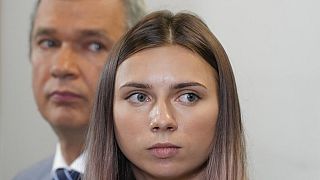 Exiled Belarusian Olympic sprinter Krystsina Tsimanouskaya, right, speaks to reporters in Warsaw on Wednesday accompanied by dissident former minister Pavel Latushka