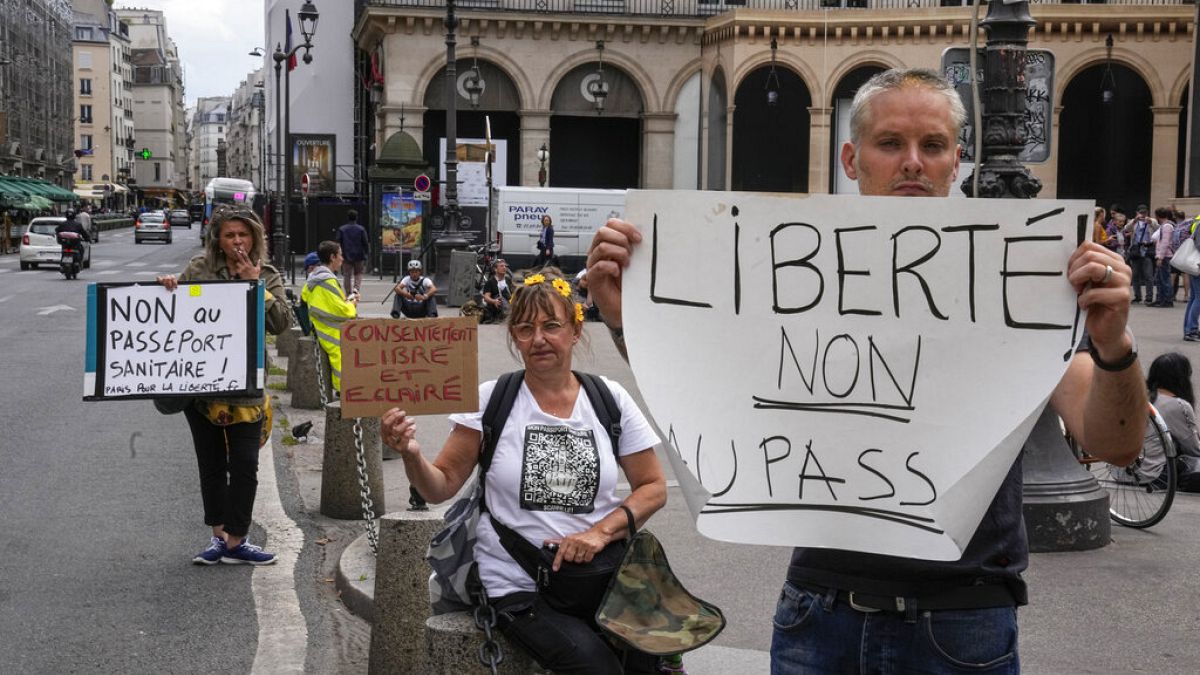 Anti heath pass demonstrators hold placards that read, liberty no to the health pass, outside the Constitutional Council in Paris, Thursday, Aug. 5,2021