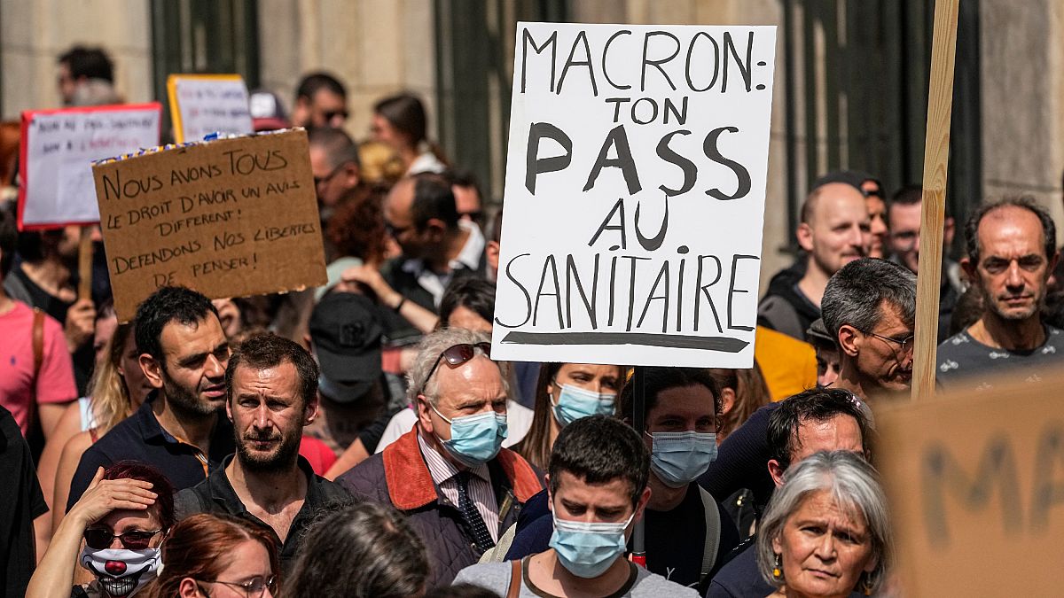 Un manifestante antivacunas sostiene una pancarta en la que se lee "Macron tu salud entra por el inodoro" durante una manifestación en París, el 17 de julio de 2021.
