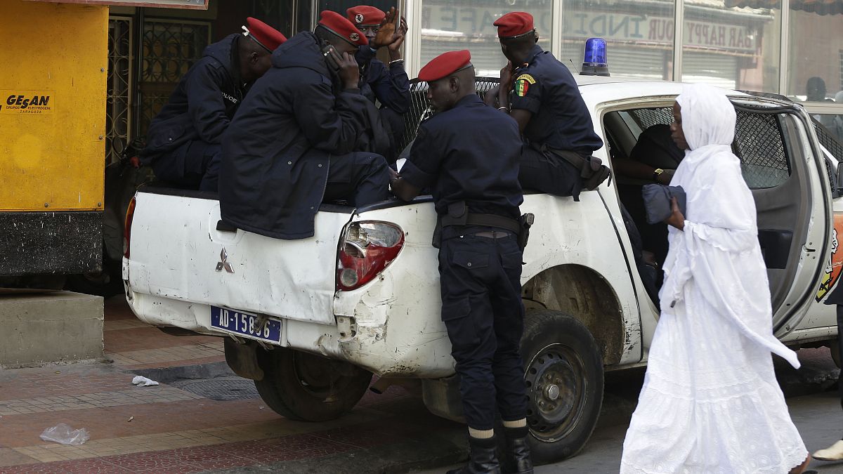عناصر من الشرطة السنغالية يجلسون في سيارتهم بأحد الشوارع وسط العاصمة داكار