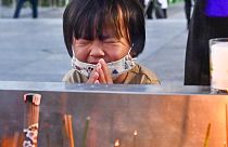 Una bambina prega di fronte al cenotafio di Hiroshima