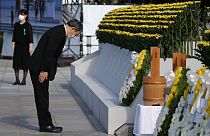 Japan's Prime Minister Yoshihide Suga pays his respects during a ceremony to mark the 76th anniversary of the Hiroshima atomic bomb attack.
