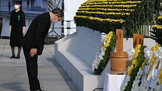 Japan's Prime Minister Yoshihide Suga pays his respects during a ceremony to mark the 76th anniversary of the Hiroshima atomic bomb attack.