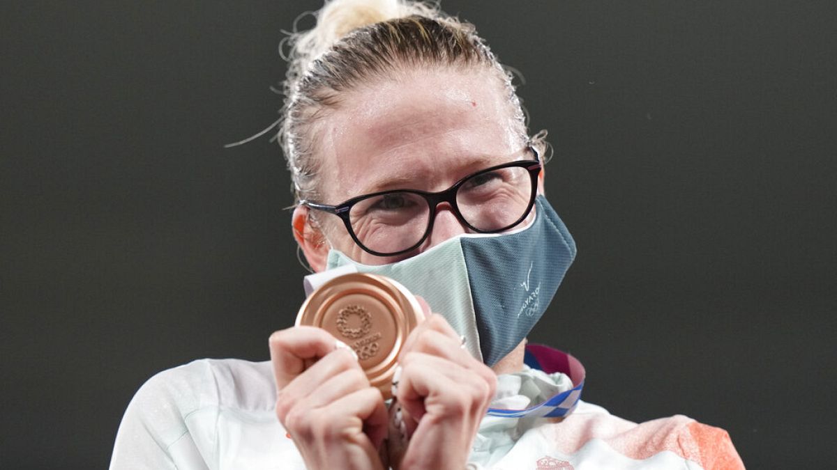 Sarolta Kovacs of Hungary celebrates on the podium with the bronze medal she won in women's modern pentathlon