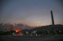 حريق غابات، في الخلف يساراً ، يقترب من محطة كيميركوي الحرارية للطاقة  على اليمين، في ميلاس، موغلا، تركيا، الثلاثاء 3 آب/  أغسطس، 2021.