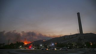 حريق غابات، في الخلف يساراً ، يقترب من محطة كيميركوي الحرارية للطاقة  على اليمين، في ميلاس، موغلا، تركيا، الثلاثاء 3 آب/  أغسطس، 2021.