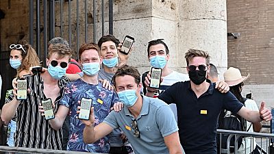 Visitors show their Covid-19 certificates before entering the Ancient Colosseum in Rome on August 6, 2021, as Italy made the Green Pass compulsory. 