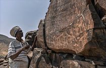 إبراهيم دابل، وهو يفسر النقوش على الصخور البركانية للحياة البرية.