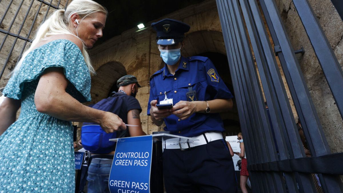 Сотрудники службы безопасности проверяют у посетителей "зелёный паспорт" на входе в Колизей в Риме