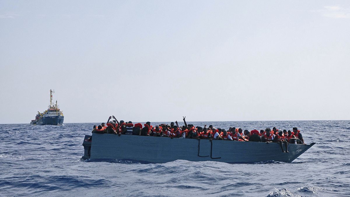 In this photo taken on Aug. 2, 2021 a boat overcrowded with migrants is waiting to be rescued by Sea Watch 3 in the Mediterranean sea. 