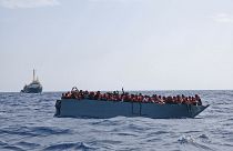 In this photo taken on Aug. 2, 2021 a boat overcrowded with migrants is waiting to be rescued by Sea Watch 3 in the Mediterranean sea.