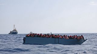 In this photo taken on Aug. 2, 2021 a boat overcrowded with migrants is waiting to be rescued by Sea Watch 3 in the Mediterranean sea. 