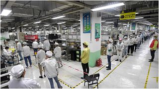 عمّال في مصنع فوكسون بمدينة ووهان الصينية يصطفون في طوابير للخضوع لفحص كشف الإصابة بفيروس كورونا