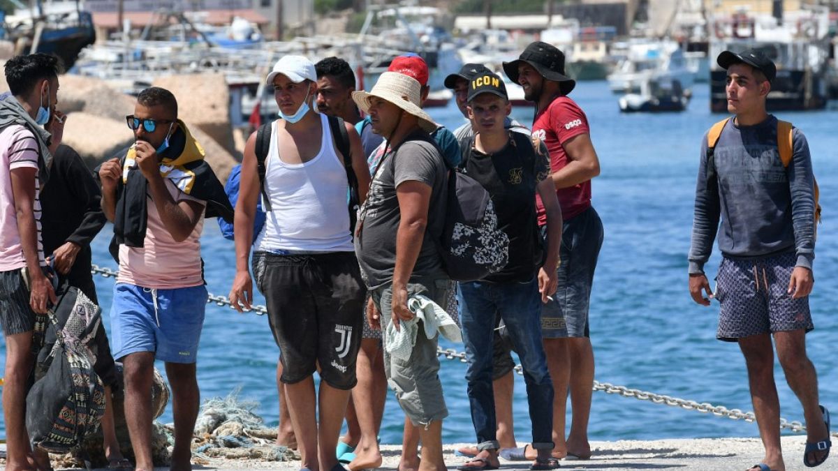 Migrants from Tunisia disembark from a 'Guardia di Finanza' patrol boat, on the Italian Pelagie Island of Lampedusa on August 1, 2020.