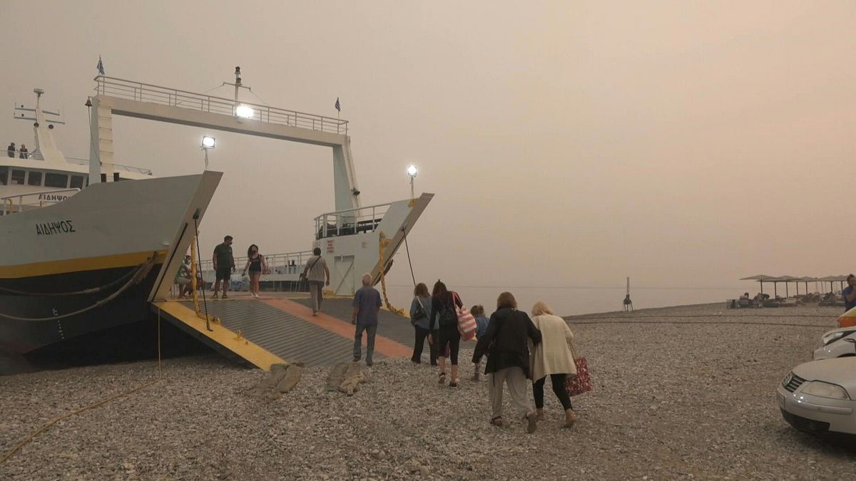 سكان جزر إيفيا اليونانية  يلجؤون إلى سفينة بعد الفرار من الحرائق.