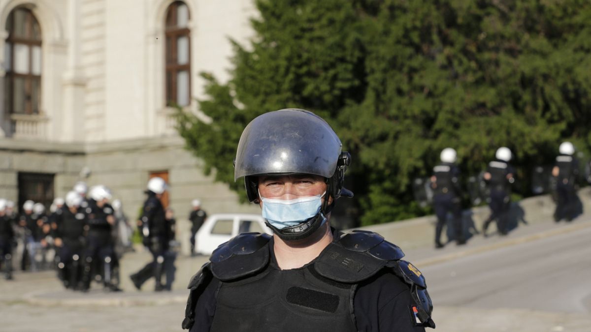 Rendőrök védik a szigorítás-ellenes tüntetőktől a parlament épületét Belgrádban