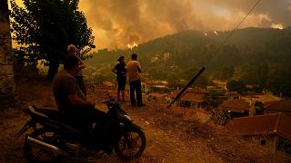 Az Évia szigetén fekvő Gouves lakó nézik a településhez közelítő lángokat egy dombról