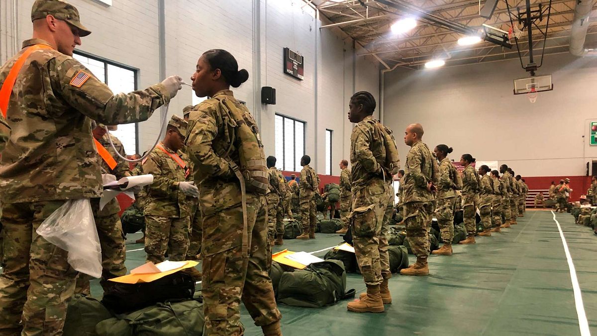 يتم أخذ درجات حرارة خريجي التدريب القتالي الأساسي للجيش الأمريكي عند وصولهم إلى فورت لي، فرجينيا، الولايات المتحدة، 31 مارس 2020