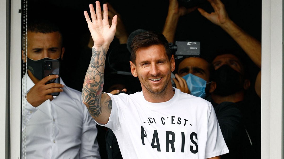 Lionel Messi, à son arrivée à l'aéroport du Bourget, en région parisienne, portant un t-shirt avec le slogan du PSG "Ici, c'est Paris", le 10 août 2021 