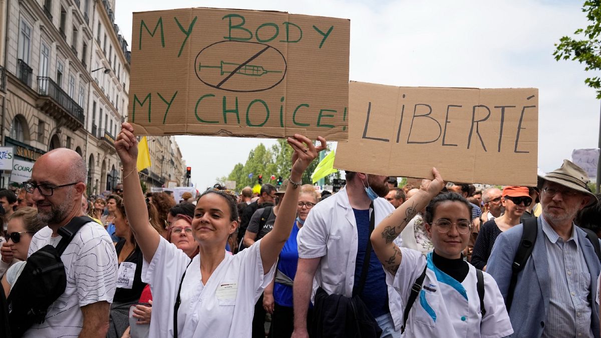 Nurses hold placards as they march during an anti-health pass protest in Paris, Saturday, July 17, 2021. 