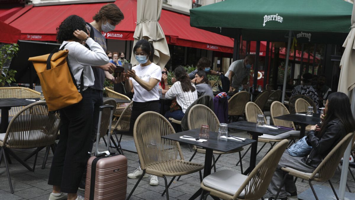 Una cameriera controlla il pass sanitario dei clienti in un ristorante a Parigi