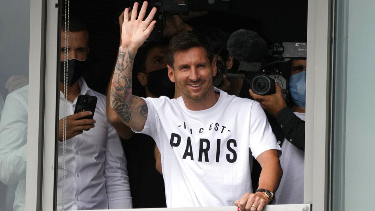 Lionel Messi waves after arriving at Le Bourget airport, north of Paris, Tuesday
