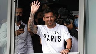 Lionel Messi waves after arriving at Le Bourget airport, north of Paris, Tuesday