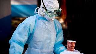 Oct. 8, 2014 photo, a medical worker carries a meal to a man being quarantined after coming into contact  with a carrier of the Marburg Virus