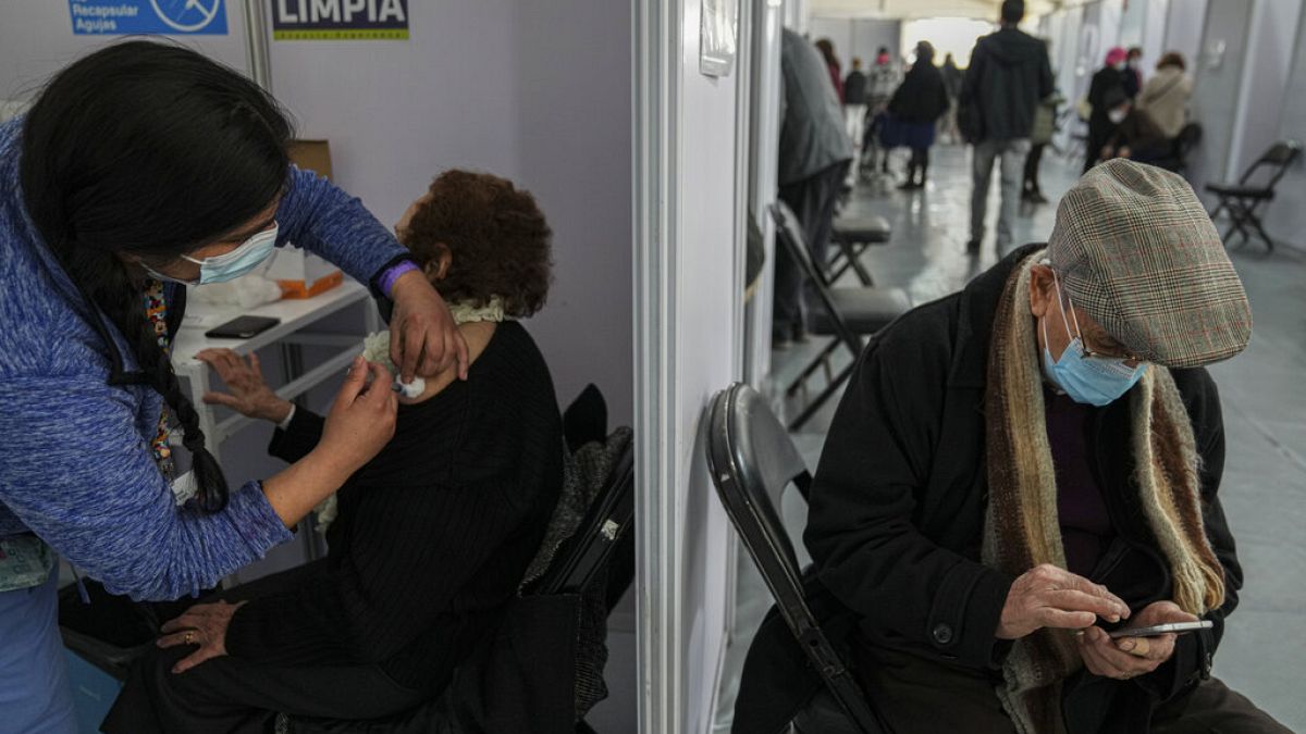 Una anciana recibe la tercera dosis de la vacuna contra la COVID-19 en el Estadio del Bicentenario de Santiago