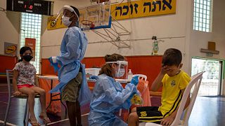 الطاقم الطبي يجري اختبار فيروس كورونا على الأطفال في ملعب لكرة السلة تحول إلى مركز لاختبار فيروس كورونا، في بنيامينا، إسرائيل، الثلاثاء 29 يونيو 2021